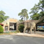 the entrance to the Jurapark with a big dinosaur statue